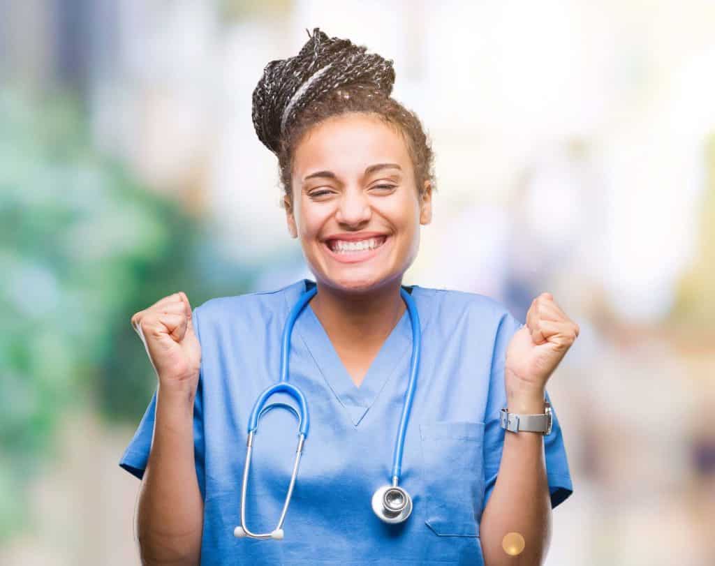 Happy nurse smiling with arms clenched in excitement.