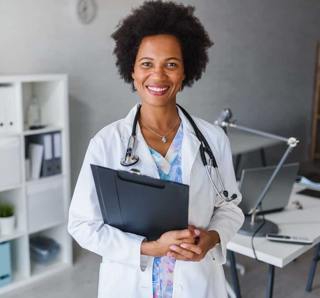 Friendly female doctor smiling and holding patient file.